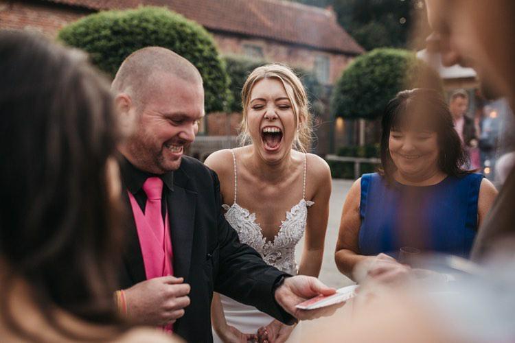 Derby Wedding Magician performing magic trick at Hazel Gap Barn in Nottingham whilst bride is laughing